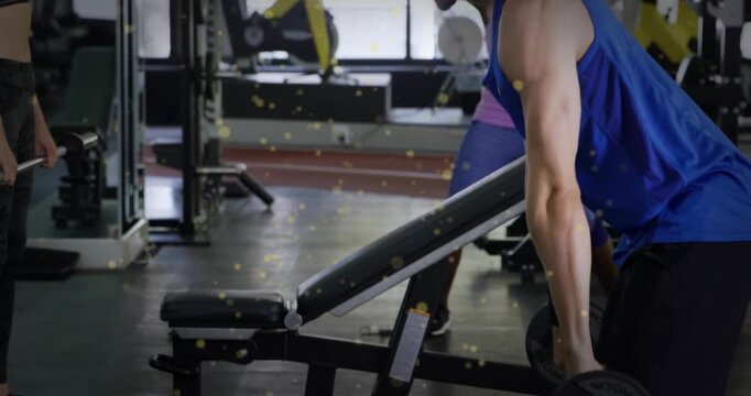 Man bracing then hinging from upright to bent-over near bench, lowering dumbbells for gym strength