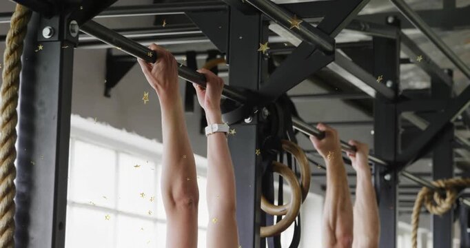 Training partners doing pullups in fitness gym, starting pull from hang, animated stars overlaying