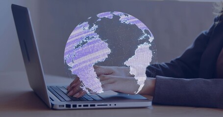 Typing worker in dark blazer using silver laptop with left ports at office desk, projecting globe