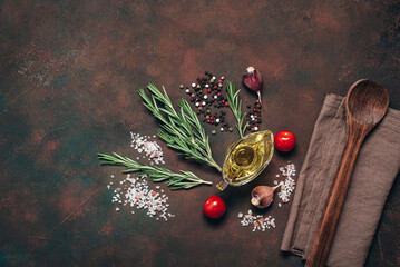 Wooden spoon and cooking ingredients, herbs, and spices on a dark background. Culinary background. Top view, flat lay.