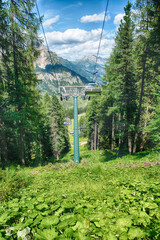Chairlift going up Rosengarten Group mountains in summer, Dolomites, Italy