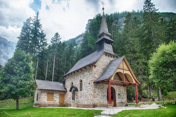 Chapel standing on Lake Braies in the Italian Dolomites