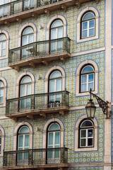 Obraz premium Traditional Portuguese Building Facade with Ornate Azulejo Tiles and Wrought Iron Balconies, Lisbon, Portugal.