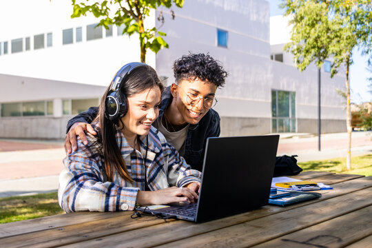 University students studying together on laptop outdoors