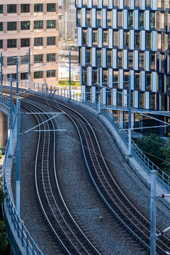 Curved railway tracks through city beside buildings showing transit flow and guiding way route and future destination in urban future