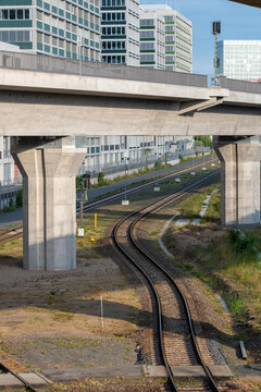 Railway tracks under concrete viaduct showing industrial infrastructure that defines way route and future destination for urban transport