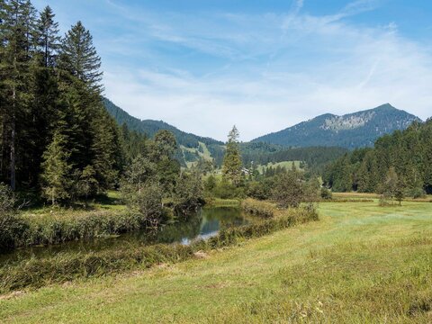  Die M&auml;ander des Flusses Rote Valepp im von Wiesen umgebenen Tal zwischen der Winterh&uuml;tte Bleckstein und der Albert-Link-H&uuml;tte, mit Blick auf die Brecherspitze, die sich &uuml;ber dem Spitizingsee erhebt
