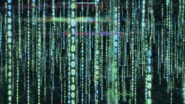 A digital cascade of green and blue binary code streams downwards on a dark background