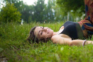 Person Lying on Grass Beside Wheelchair in Park