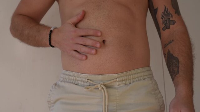 Man checking belly fat and bloating