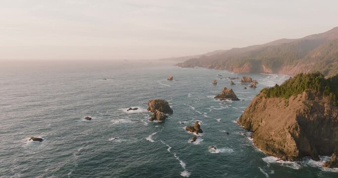 Aerial view of rugged coastline with scattered rocks and cliffs meeting the vast ocean, creating a dynamic contrast of textures, Brookings, Oregon, United States.