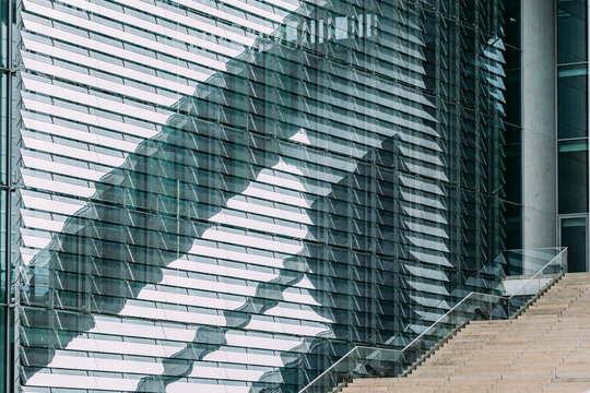 Modern glass architecture facade with reflection pattern and geometry lines in urban setting featuring a staircase element in contemporary design