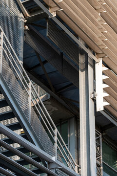 Industrial metal staircase architecture detail with structure beams and framework angles creating shadows and strong perspective in urban setting