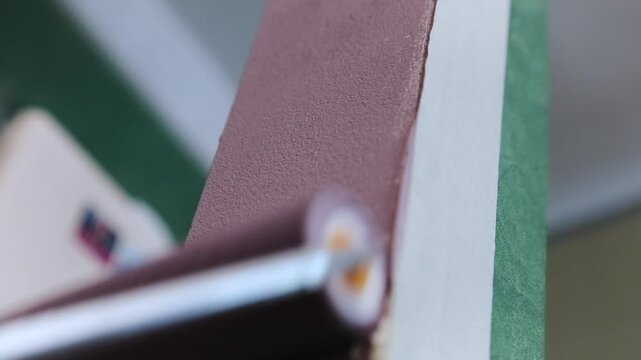 Close shot. Painting the wall with a roller in raspberry color