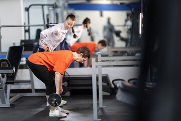 Obraz premium Senior woman exercising with personal trainer in gym