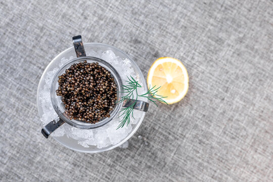 Premium Black Sturgeon Caviar with Lemon and Dill on Ice. View from the top