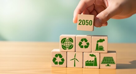 Hand stacking wooden blocks with environmental icons and the year 2050