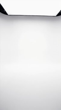 Muted, clean, empty photography studio interior with bright white walls and floor.