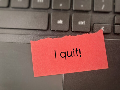 I quit message written on a note placed on a laptop keyboard, symbolizing resignation, burnout, career change, stress, and workplace decision concept.