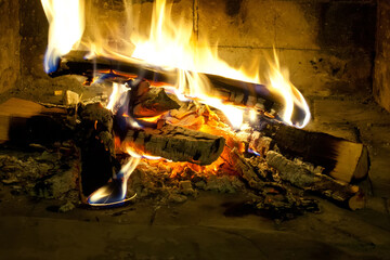 Burning firewood in a fireplace, mantelpiece. Flames fire wooden logs, close-up
