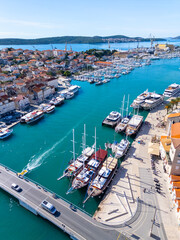 Aerial view of Trogir old town with turquoise Adriatic water, luxury yachts, marina, promenade and red tiled roofs on a sunny day in Dalmatia, Croatia