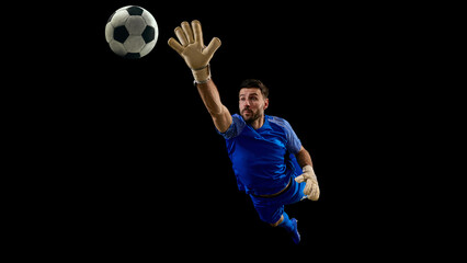 Obraz premium Soccer goalkeeper reaching for ball during airborne save attempt. Concept of reflex reaction, last second defense, high reach save, sports advertising, football training visuals, and match highlights.