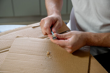Close-up of hands sharpening a pencil with a sharpener on a desk. Concept of preparation, focus, creativity, learning, and project development. Manual work, no face visible.