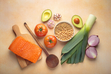 Fresh salmon, vegetables, legumes, leeks and wooden cooking spoon creating healthy meal ingredients