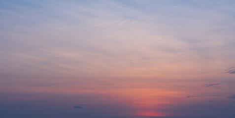 Soft pastel sunset sky with gentle clouds in warm and cool tones.