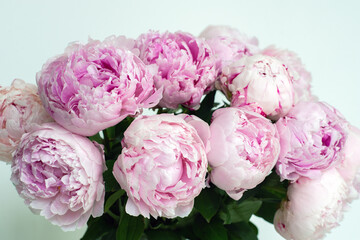 Soft pink peonies in a glass vase