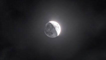 Obraz premium Waning crescent moon in a starry night sky with gentle halo glow.