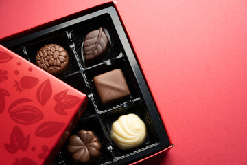 Luxury assorted chocolates with copy space on red surface
