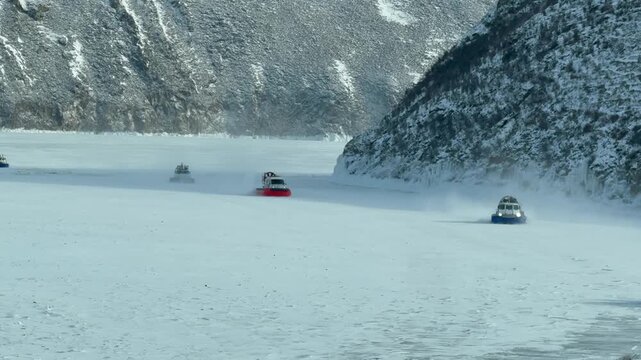 Video of Khivus hovercrafts transporting a group of tourists from Olkhon Island to the village of Sakhyurta across the frozen Olkhon Gate Strait on a cold snowy day.  Winter travel and adventure