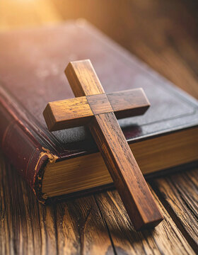 Handcrafted wooden cross on vintage Bible, wooden table, spirituality, Christian faith, cultural artifact.