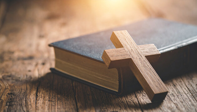 Handcrafted wooden cross on vintage Bible, wooden table, spirituality, Christian faith, cultural artifact.