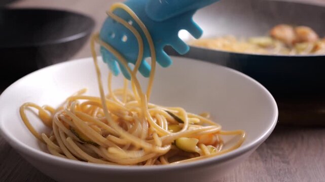 Il cuoco prende gli spaghetti dalla pentola e li mette nel piatto