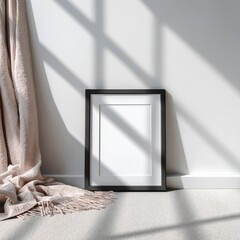 A blank picture frame lies on the floor beside a curtain in a well-lit room with shadows casting on the wall