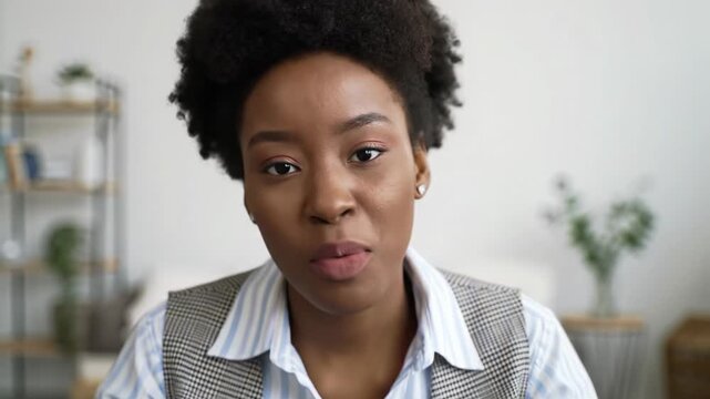 Diverse young adult (25-35) in business-casual attire, engaging smile, subtle hand gestures, looking directly at video, professional mcu with slow push-in, modern office with soft bokeh, digital