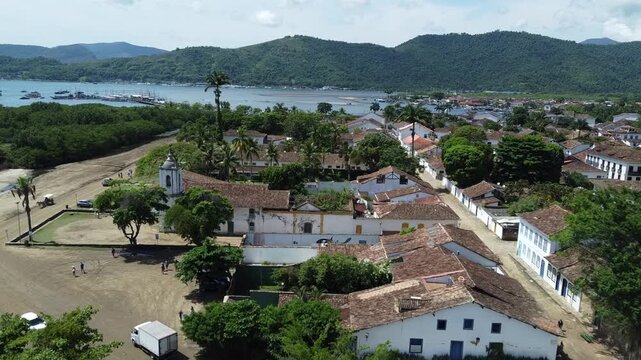 Aerial shot of Paratys UNESCO historic center with view over the bay and the majestic mountains. Captures colonial architecture, the Atlantic forest, and the bay from above.