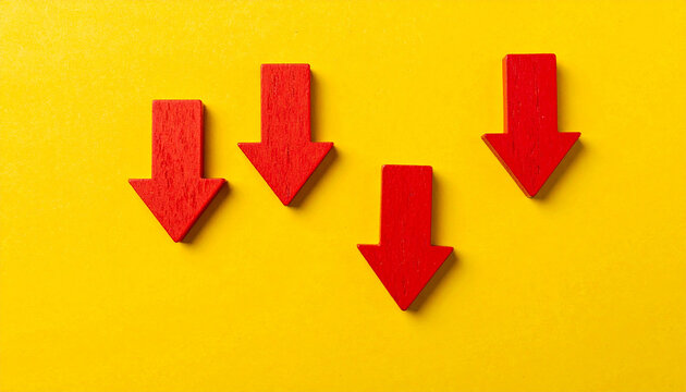 Red wooden arrows pointing downward on yellow backdrop, business failure and economic loss concept