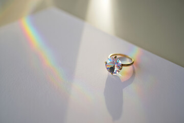 Golden ring with diamond and rainbow light reflection on white surface, for jewelry advertising or mockup, isolated on transparent background, png