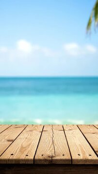 An empty wooden table provides a perfect foreground for a beautiful, blurred tropical beach scene. This peaceful setting is ideal for product displays