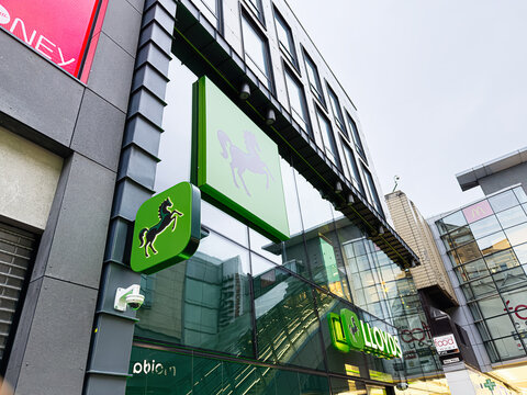 Lloyds bank sign on a modern Manchester city center building with glass facade in the UK