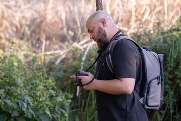 Photographer Checking Captured Images on Digital Camera. Photographer Reviewing Photos on Camera Screen. Photographer Checking Camera Screen Outdoors. Photographer Reviewing Shots After Shooting.