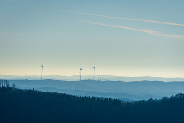 Wind turbines on misty hills at dawn