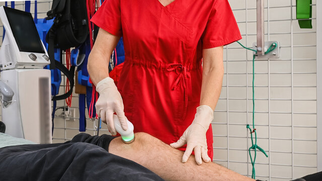 Ultrasound therapy applied to knee during physiotherapy session. Handheld transducer delivers sound waves to soft tissue, improving circulation, reducing pain, supporting muscle and joint recovery
