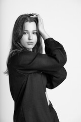Young woman posing in black and white, wearing a stylish jacket