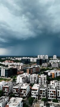 An aerial view of a modern city with residential and office buildings under a dark, dramatic, stormy sky, evoking a sense of impending change and chal