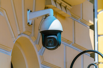 Modern security camera is fixed on a decorative wall, blending technology with classical architecture. The scene conveys a sense of safety and vigilance, with the camera's presence emphasizing protect