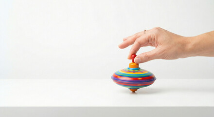 Hand spinning a colorful vintage humming top toy on white background